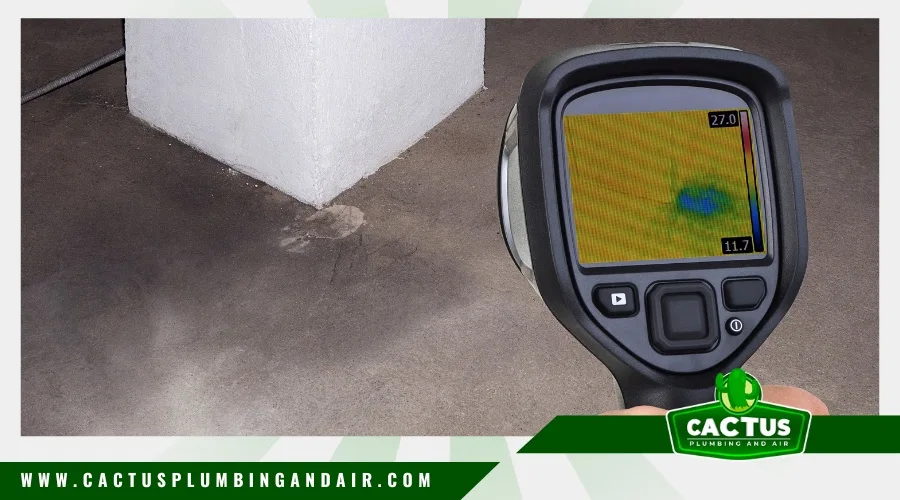 Plumber using electronic tool for slab leak detection