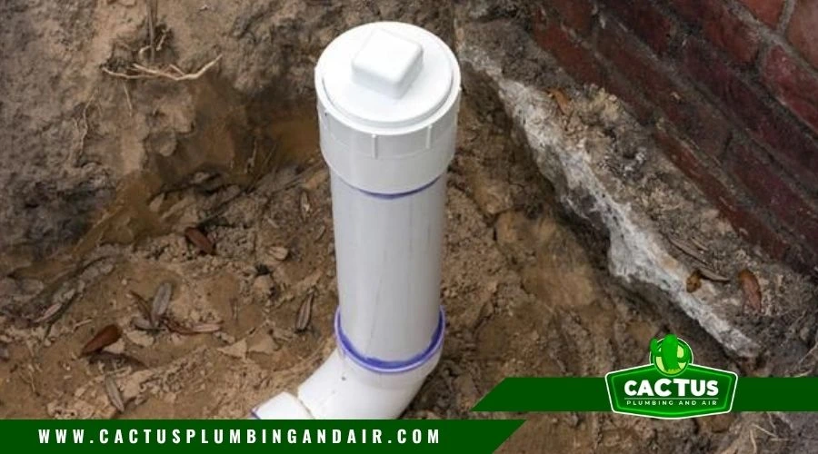 plumber locating sewer cleanout outside a home foundation
